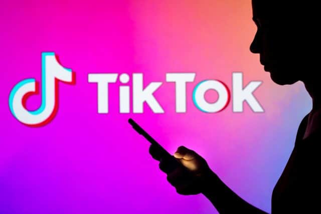TikTok logo with user silhouetted in foreground